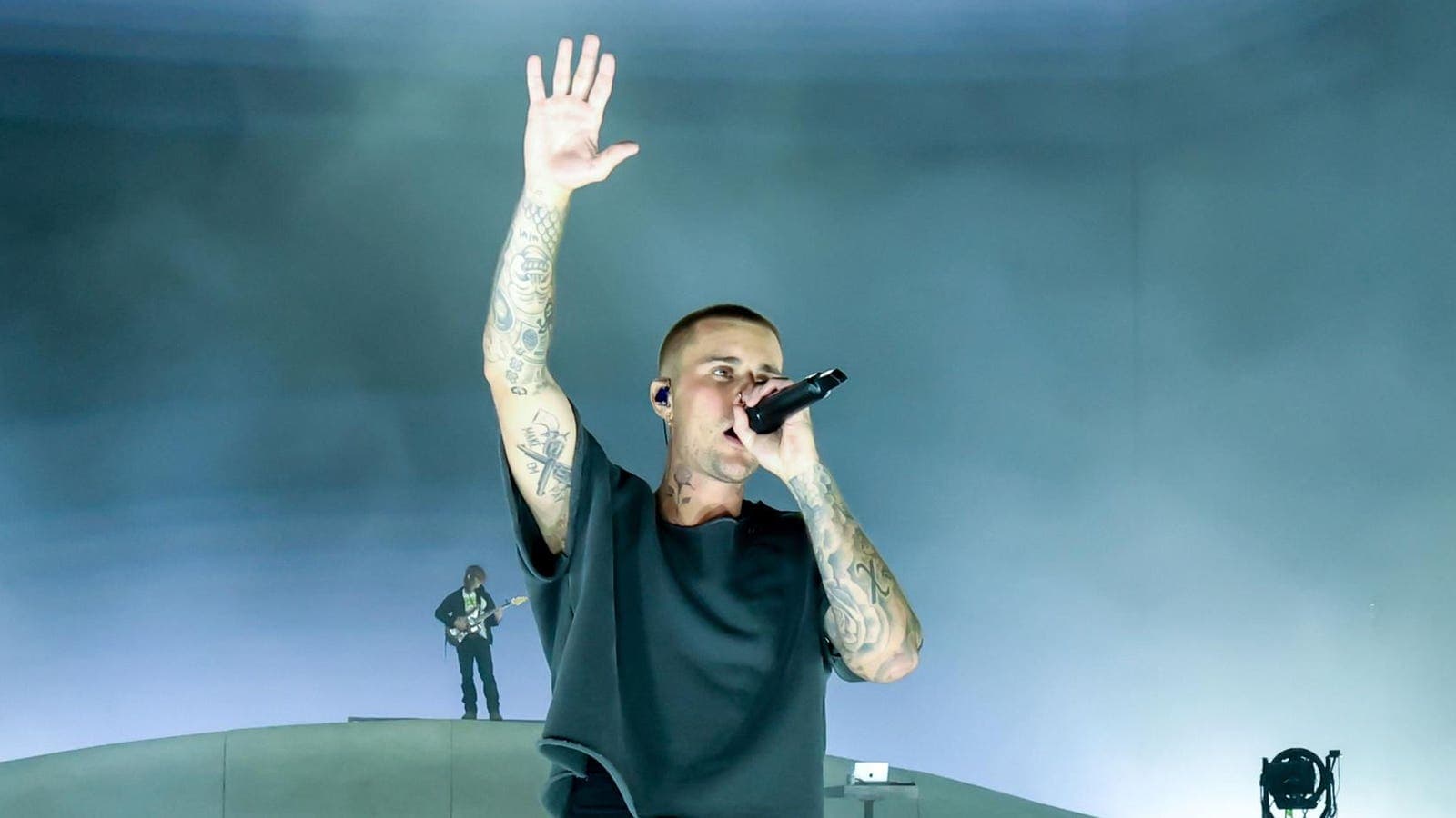 Justin Bieber performing on stage at Coachella 2026 with a projection screen displaying his music videos behind him