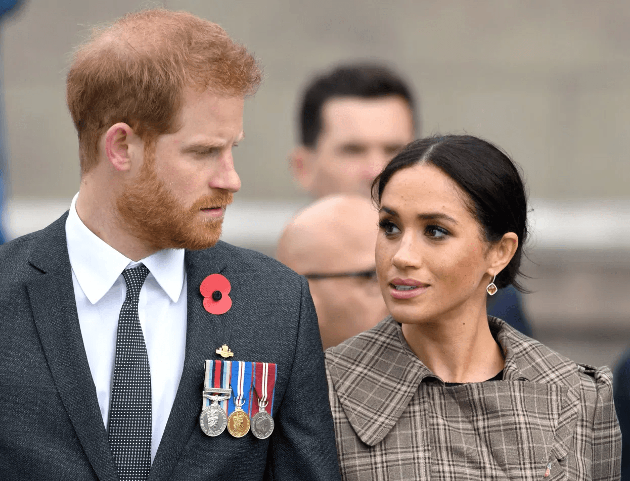 Prince Harry and Meghan Markle standing on the Buckingham Palace balcony during the 2019 Trooping the Colour ceremony, surrounded by members of the Royal Family