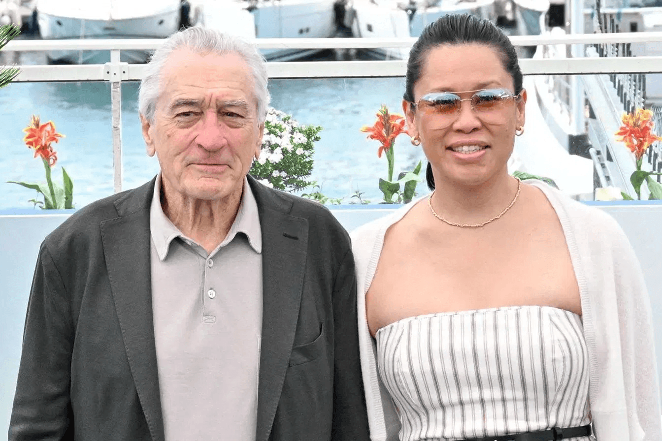 Robert De Niro and Tiffany Chen walking hand in hand on the red carpet at the Chanel Tribeca Festival Artists Dinner in New York