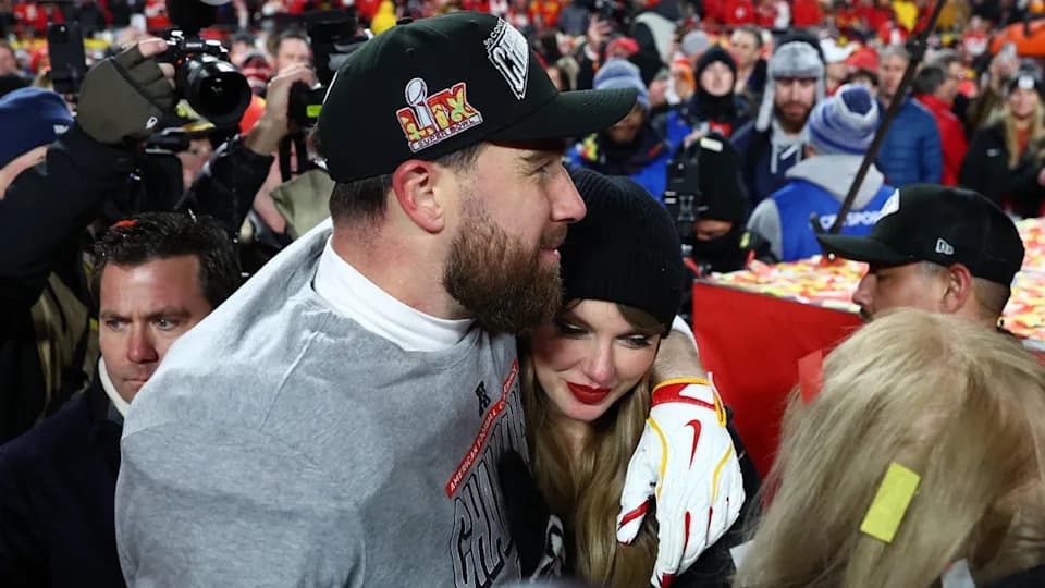 Taylor Swift and Travis Kelce smiling together at a public event