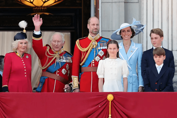 King Charles and Queen Camilla waving from an open carriage along The Mall during the Trooping the Colour procession, with crowds lining the street behind them