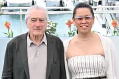 Robert De Niro and Tiffany Chen walking hand in hand on the red carpet at the Chanel Tribeca Festival Artists Dinner in New York