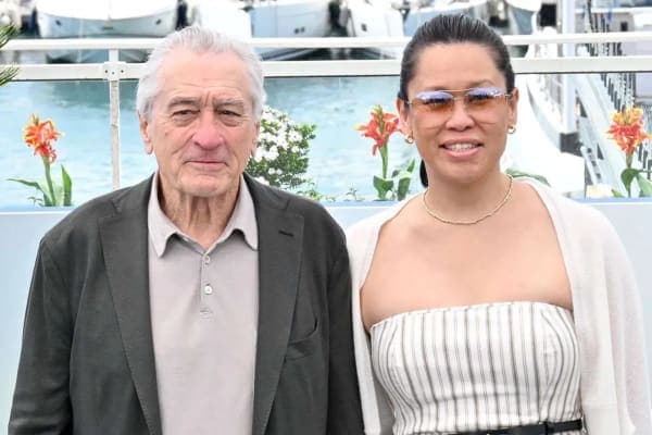 Robert De Niro and Tiffany Chen walking hand in hand on the red carpet at the Chanel Tribeca Festival Artists Dinner in New York