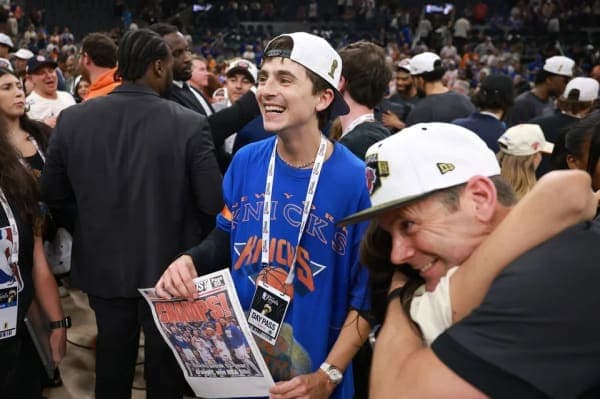 Timothée Chalamet wearing a New York Knicks T-shirt and cheering courtside during the NBA Finals at Frost Bank Center in San Antonio