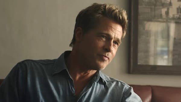 Brad Pitt at a public event, looking thoughtful in a dark suit