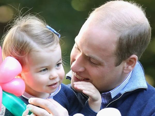 Prince William in Welsh Guards dress uniform standing alongside Princess Charlotte in the garden of Kensington Palace following Trooping the Colour