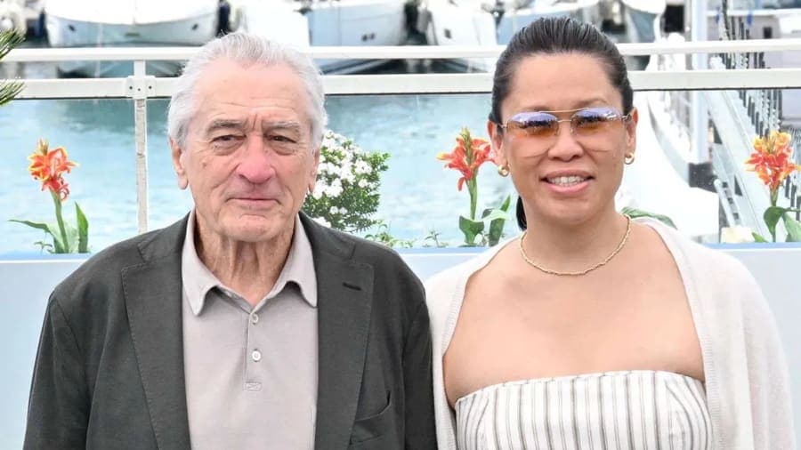Robert De Niro and Tiffany Chen walking hand in hand on the red carpet at the Chanel Tribeca Festival Artists Dinner in New York
