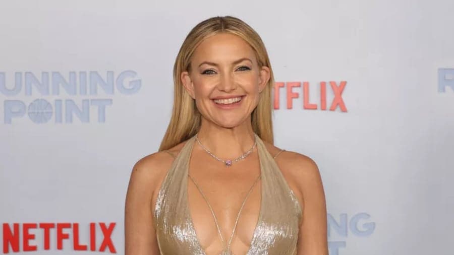 Kate Hudson smiling at a public event, wearing a spring dress
