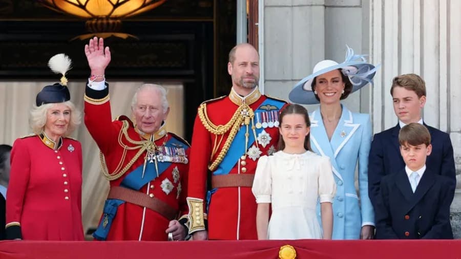 King Charles and Queen Camilla waving from an open carriage along The Mall during the Trooping the Colour procession, with crowds lining the street behind them
