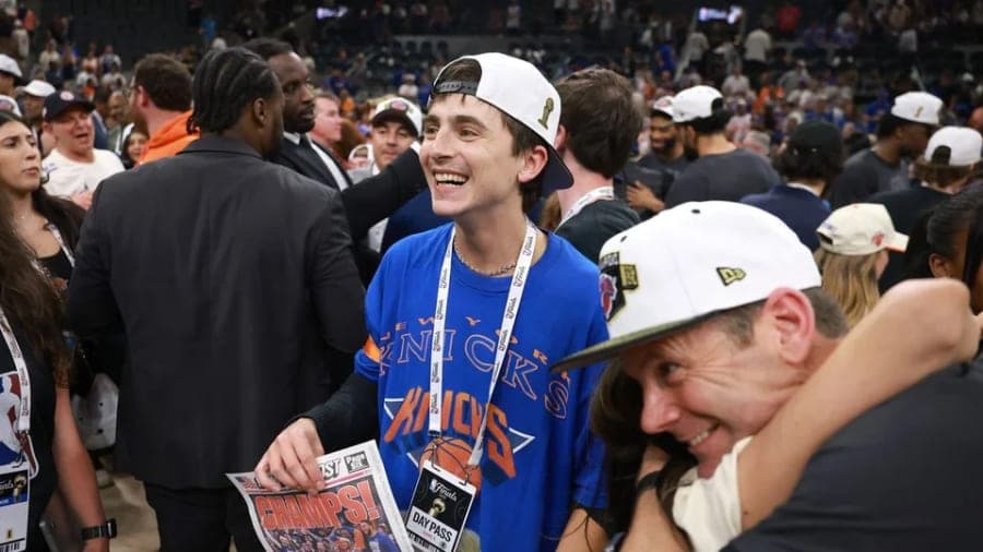 Timothée Chalamet wearing a New York Knicks T-shirt and cheering courtside during the NBA Finals at Frost Bank Center in San Antonio