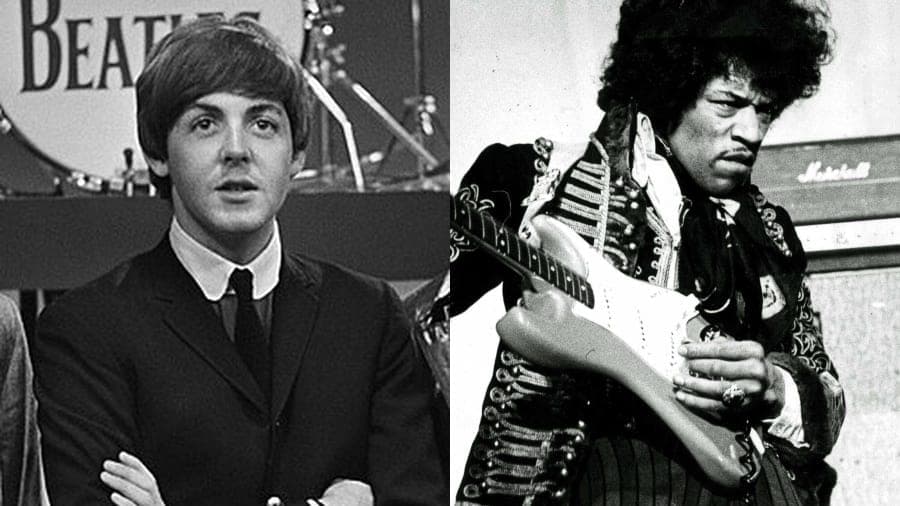 A man in a dark suit speaking into a microphone on a concert stage against a softly lit backdrop.